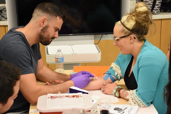 A student practicing drawing blood during the back-to-basics training in 2017.