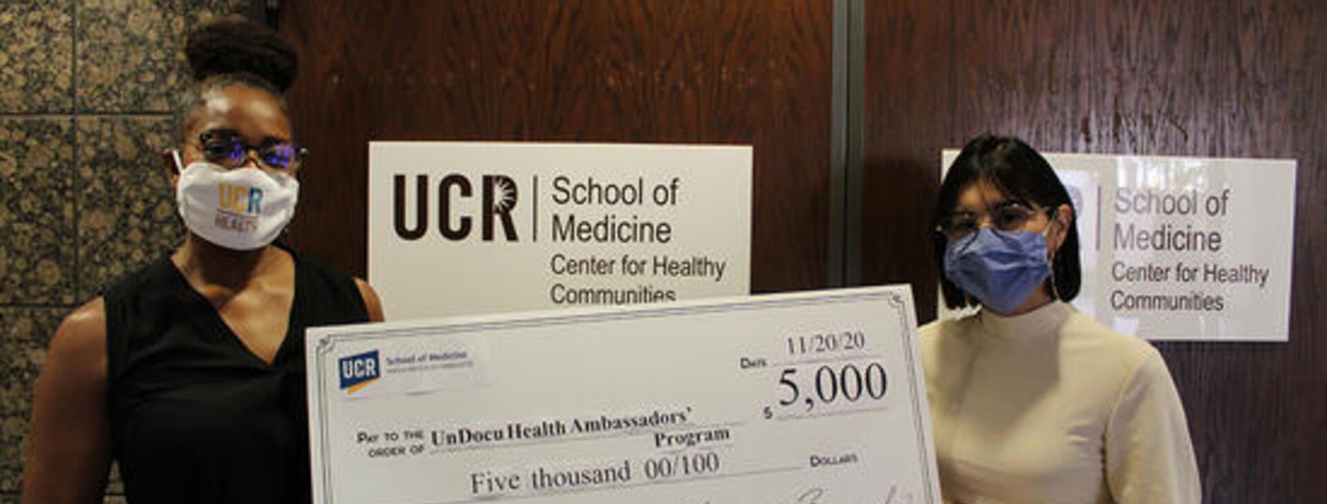student receiving check for research